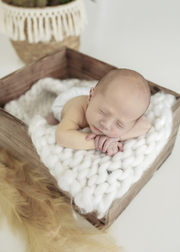 newborn baby sleeping on a white blanket with a bambam cloth nappy