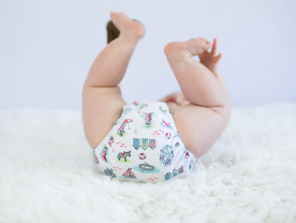toddler waring a cloth nappy with legs in the air like he does not care
