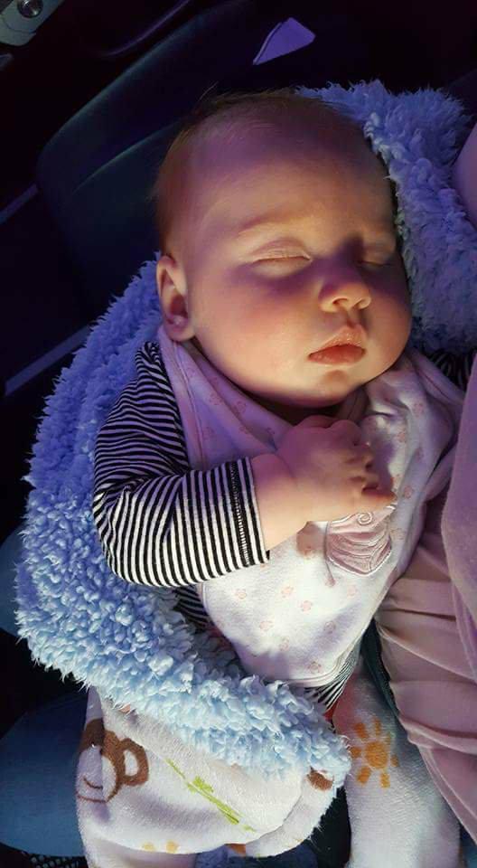 Sleeping baby in mother’s arms on a plane.