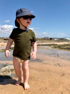 Toddler walking along the beach in Australia wearing a modern cloth all in two nappy.