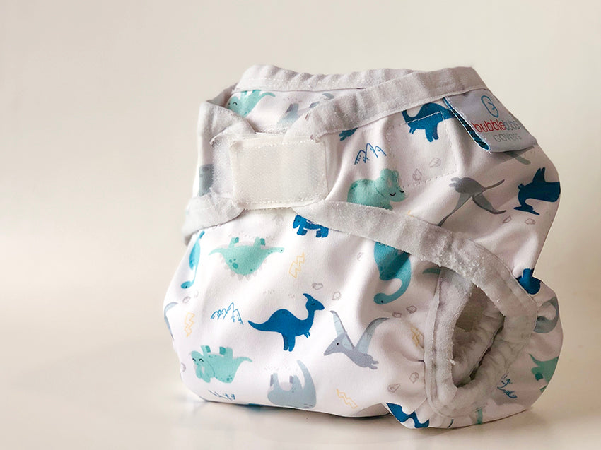 Reusable nappy cover with dinosaurs on it.