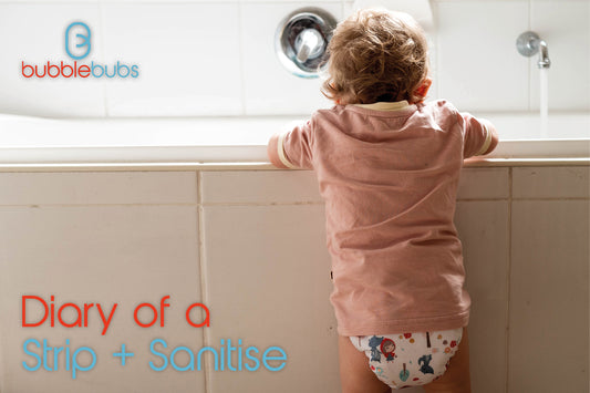 Toddler-looking-into-a-bath-tub-wearing-an-all-in-two-modern-cloth-nappy