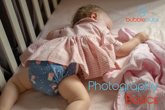 Toddler-sleeping-on-pink-sheets-wearing-a-pink-dress-and-blue-candie-by-bubblebubs-cloth-nappies-australia