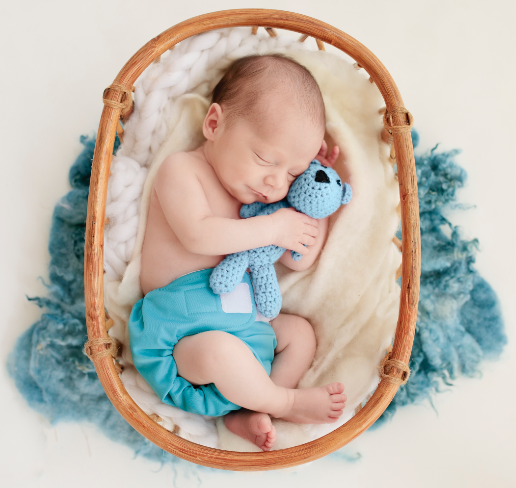 blue newborn cloth nappy on a sleeping baby with cute blue toy