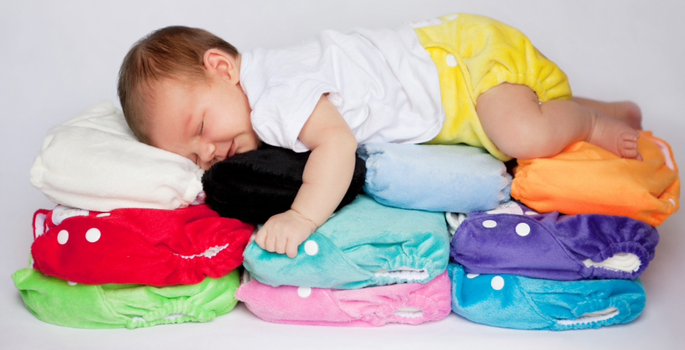 baby asleep on a pile of cloth nappies