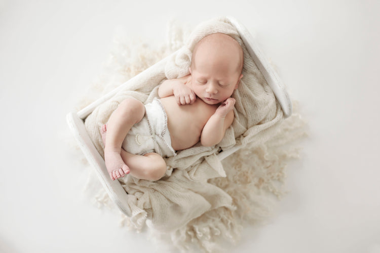 sleeping newborn baby woth a bambam cloth nappy in a crib