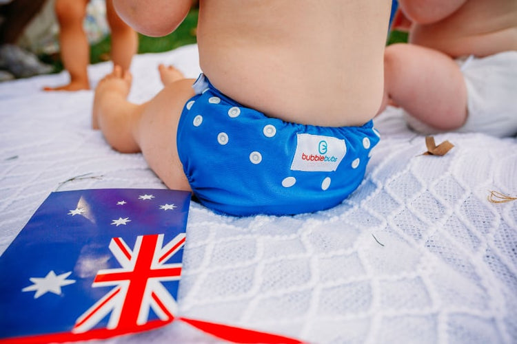 blue candie cloth nappy on a baby sitting on a white cloth with an australian flag