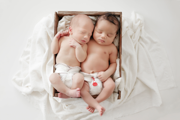 two sleeping babies waring Bambam newborn cloth nappy done up with red and white snappi