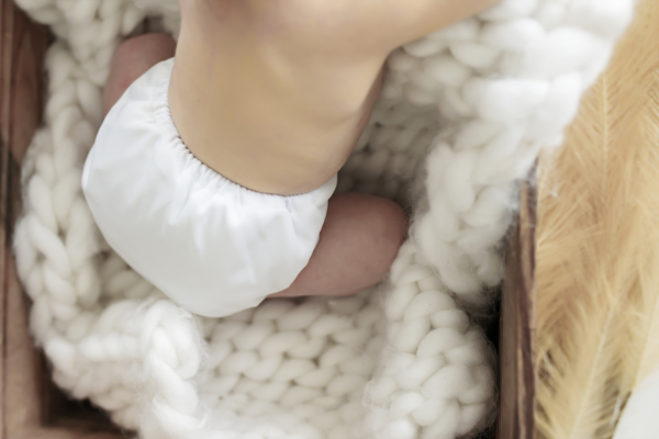 white candie cloth nappy on a newborn baby on a white blanket